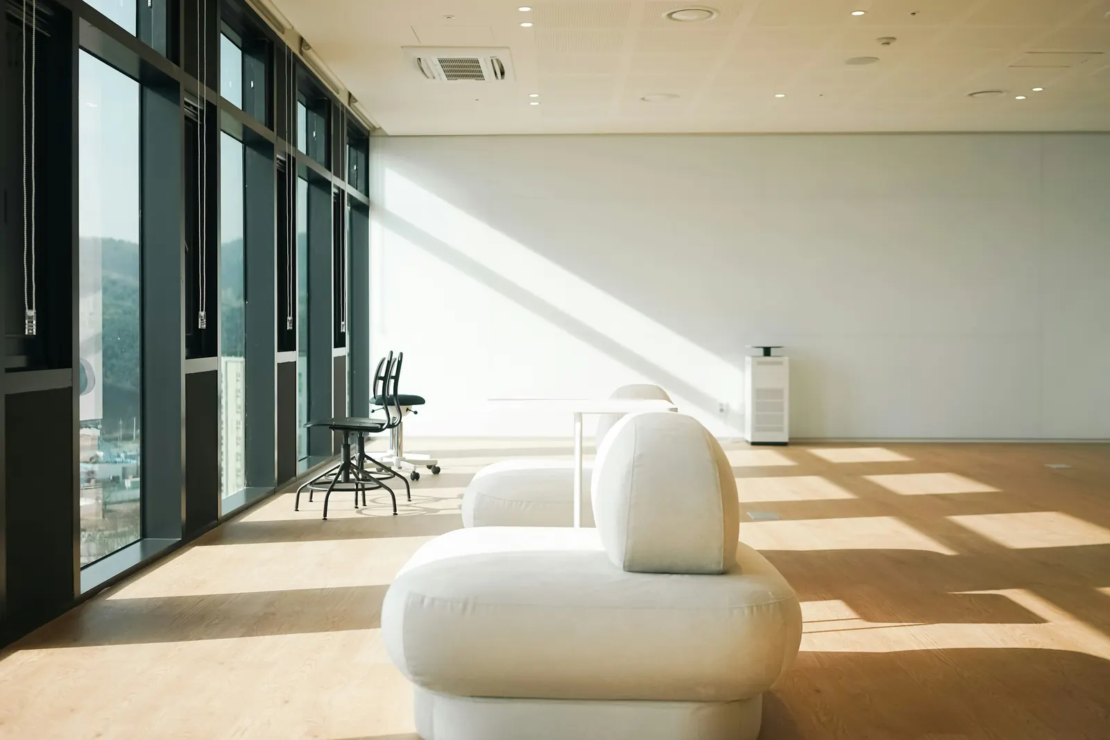 Sunlit white seating in a quiet, tidy office